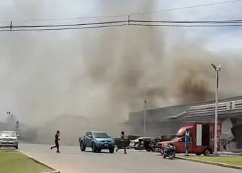 Asap mengepul dari atap sebuah toko swalayan yang terhubung dengan sebuah SPBU di Provinsi Sisaket setelah terkena serangan roket dari Kamboja. Facebook Chatchak Ratsamikaeo / AFP