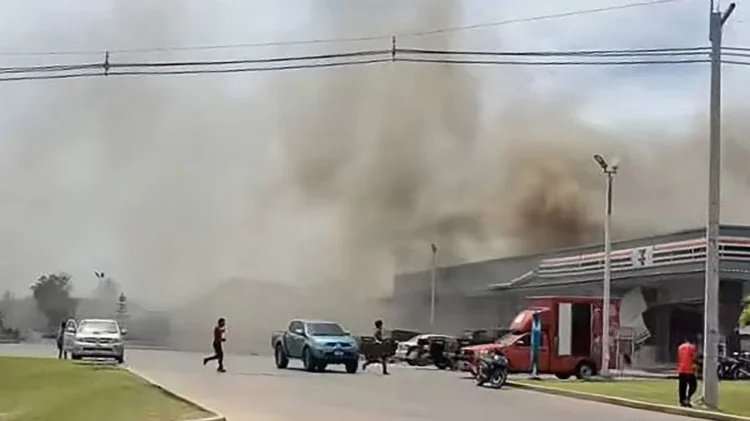 Asap mengepul dari atap sebuah toko swalayan yang terhubung dengan sebuah SPBU di Provinsi Sisaket setelah terkena serangan roket dari Kamboja. Facebook Chatchak Ratsamikaeo / AFP